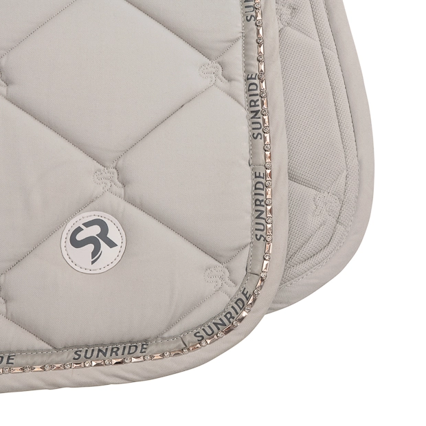 detailaufnahme der dressurschabracke wellington beige umrandet mit strasssteinen sowie fellpolsterung am widerrist von sunride