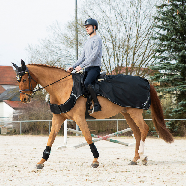 ausreitdecke derby schwarz auf einem pferd mit seinem reiter beim reiten