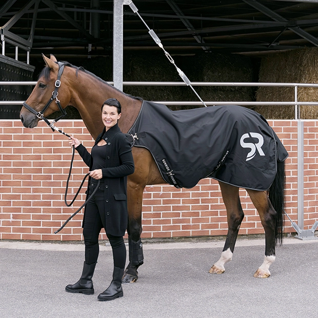 Eine Reiterin steht neben einem Pferd da Longierdecke von Sunrides eine schwarze 
