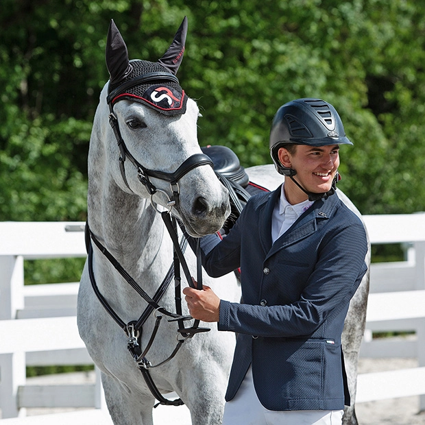 reiter und pferd mit sunride trense york sowie vorderzeug windsor in schwarz sowie passende fliegenhaube mit sr logo