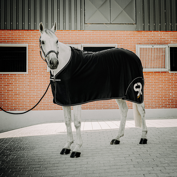 black boston cooler rug made of softshell and fleece with reflecting sr logo by sunride on a horse