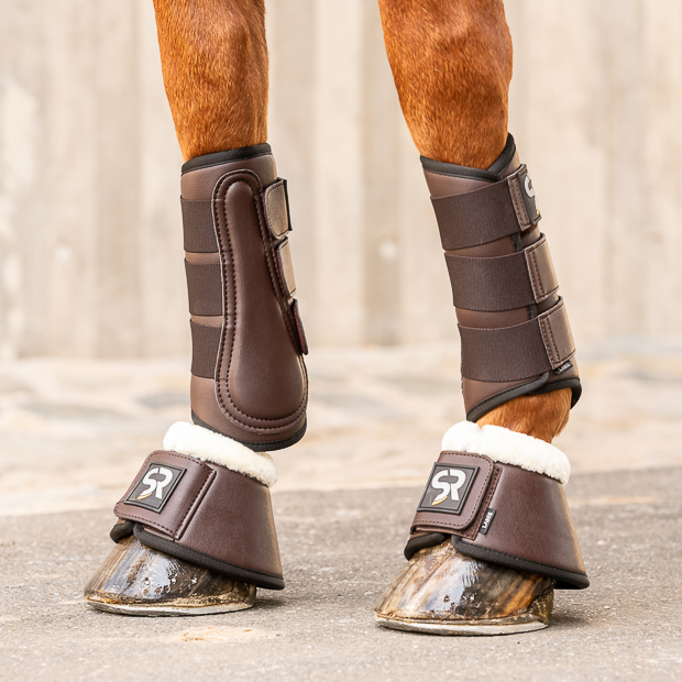 brown dressage leather boots and leather bell boots with fur in a set on a horse