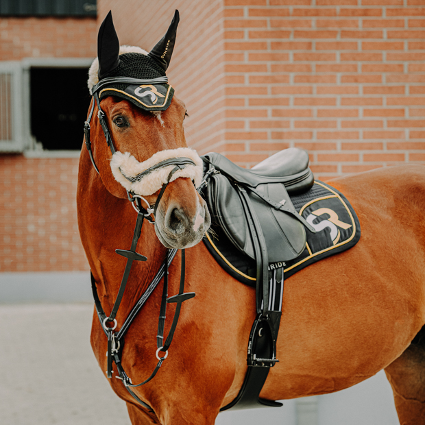 black golden sr line jumping saddle pad with breathable air mesh spine by sunride under saddle on a horse with matching fly net in sr line and sunride leather equipment