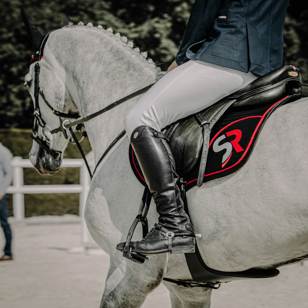 jumping saddle pad sr line black red under saddle with rider black red sr line jumping saddle pad with breathable air mesh spine by sunride under a saddle on a horse with rider