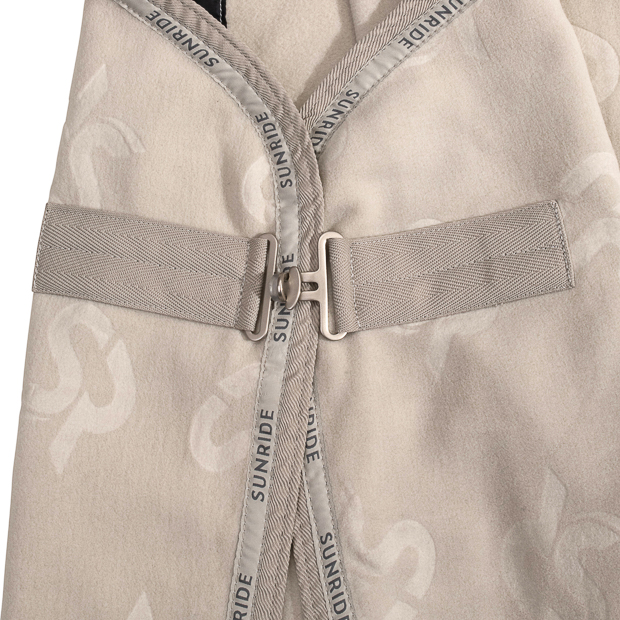 detailed view of front closure of beige cooler rug with removable belly straps wellington line by sunride