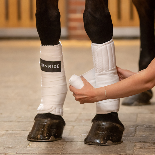 white bandaging pads with sr logo and velcro closure on horse