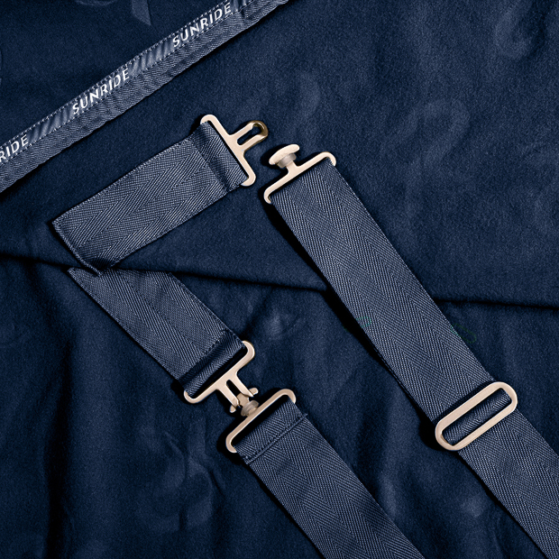 detailed view of belly straps adjustment of blue cooler rug with removable belly straps wellington line by sunride