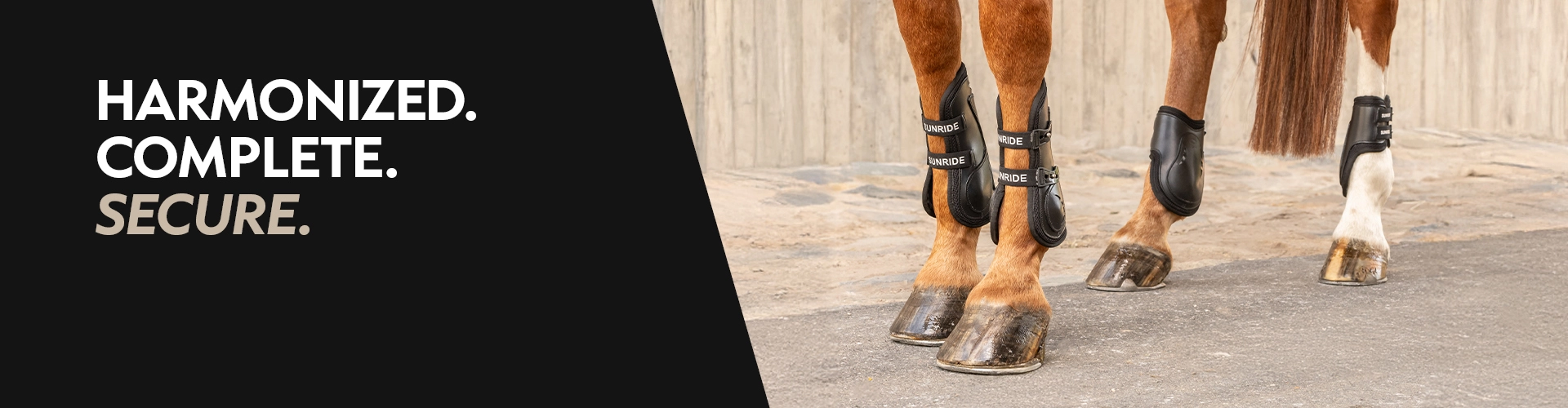 Jumping boots Four horse legs with brown boots and fetlock protectors on asphalt in front of a wall with the text Harmonized Complete Secure on the left
