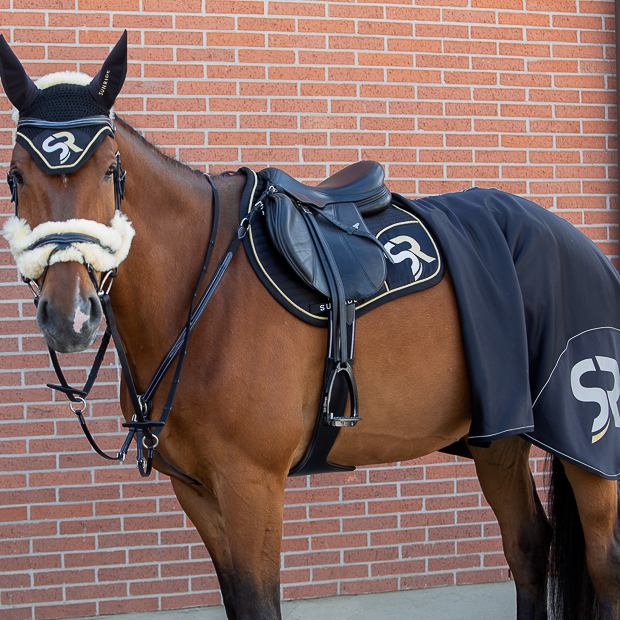 black silver sr line set with jumping saddle pad, fly earnet, bandages and cooler rug by sunride under a saddle on a horse