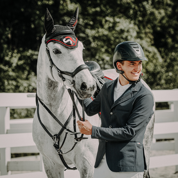 breathable dressage saddle pad red and black exclusive line with fur on withers and the matching earnet on a horse with rider