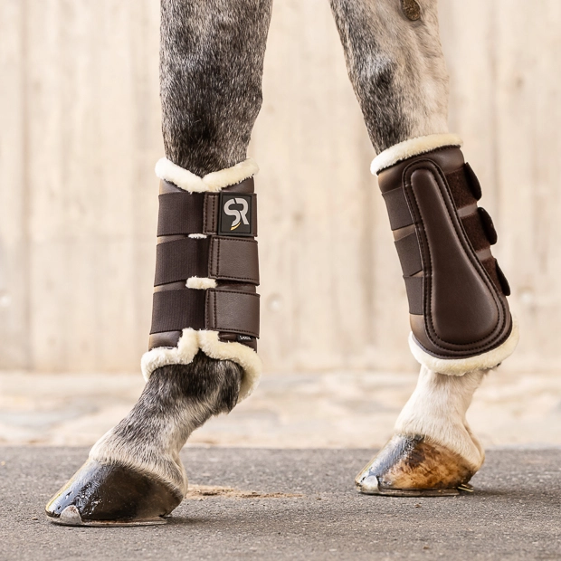 brown dressage leather boots from leather and fur inside with elastic velcro closures on horse leg
