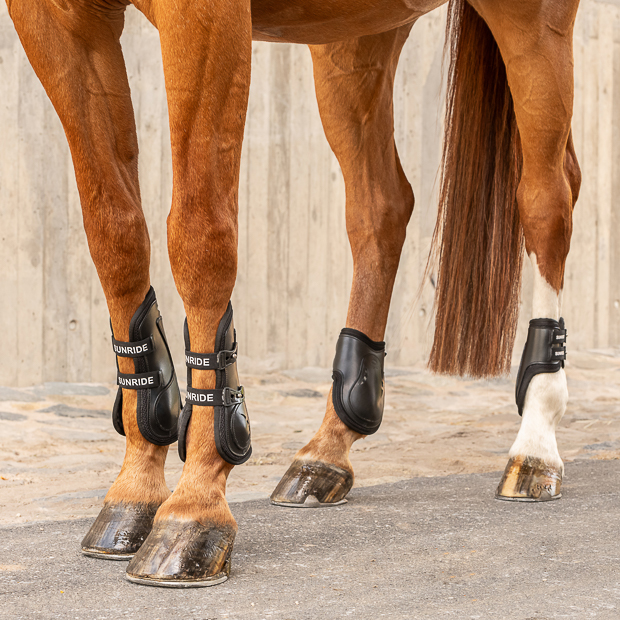 leather jumping boots black with neoprene inside and elastic straps and safety net layer and matching fetlock boots with elastic straps on a horse by sunride