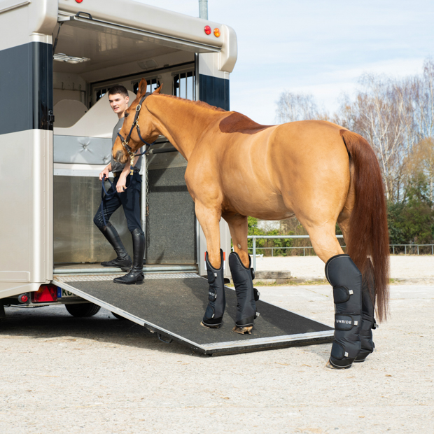 a horse walking on a trailer with reflecting black travel boots with reinforced hoof area in a set of 4 by sunride