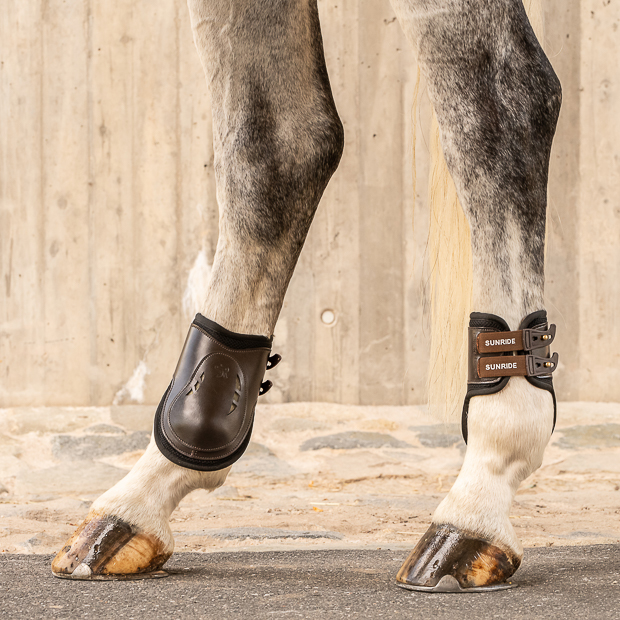  brown high leather fetlock boots with protection layer and elastic closure straps by sunride on a horse leg