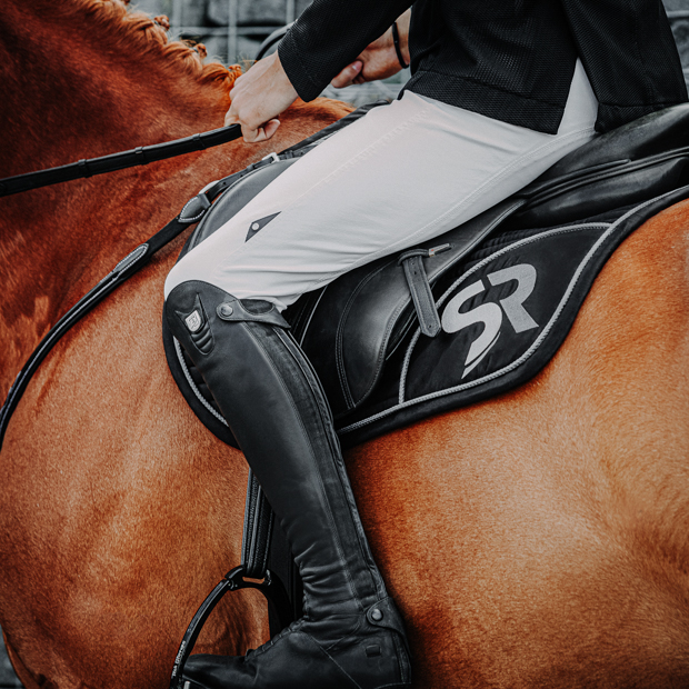 black silver sr line jumping saddle pad with breathable air mesh spine by sunride under saddle on a horse with rider