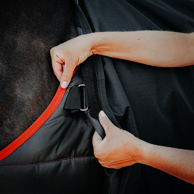 front connection of dublin black reflecting rain rug 50 grams filling and 300 grams filling under rug in a set attaching and connecting at the front rectangular padded rings the set of black rain rug dublin with 50 grams filling and reflecting elements and under rug with 300 grams filling by sunride