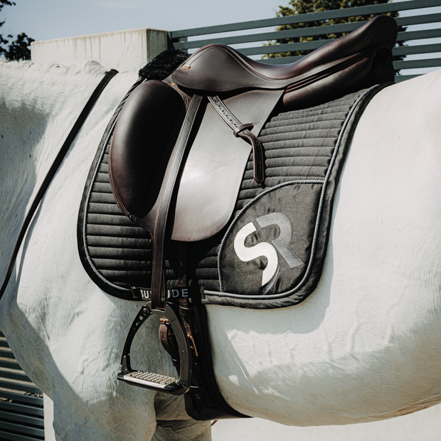 sr embroidery of breathable dressage saddle pad silver and black exclusive line with fur on withers under saddle on a horse